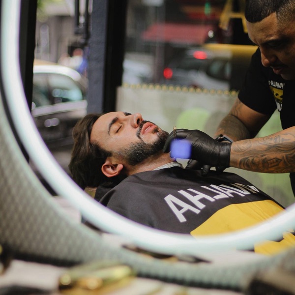 Barbeiro premium da Navalha Sampa realizando um corte